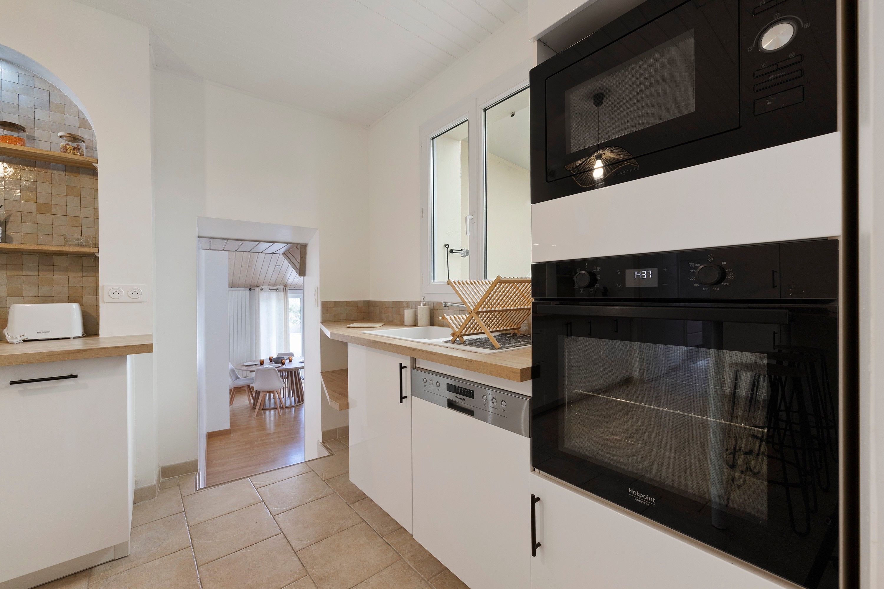 A modern kitchen with a built-in oven, microwave, and dishwasher.