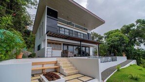 A modern two-story house with a flat roof, large windows, and a balcony. - Modern family friendly, ocean view house near Dominical - Wi-Fi, inifinity pool (Dominical)