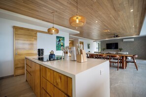 Una cocina moderna con armarios de madera, una isla central e iluminación colgante.
