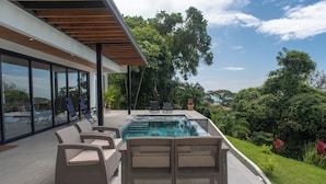 A modern outdoor pool area with wicker furniture and a view of the surrounding greenery. - Modern family friendly, ocean view house near Dominical - Wi-Fi, inifinity pool (Dominical)
