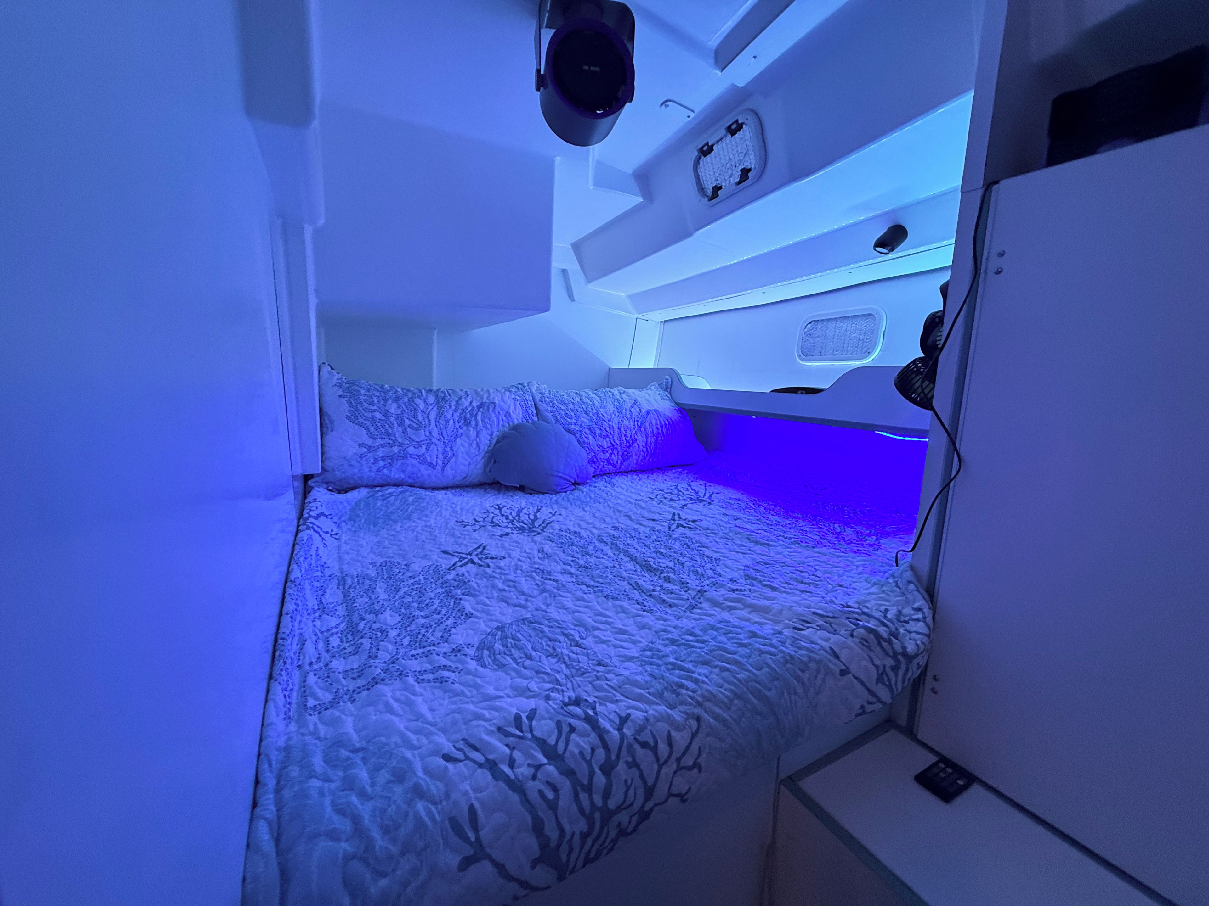 Una habitación compacta con literas, un escritorio pequeño y una lámpara en el techo.