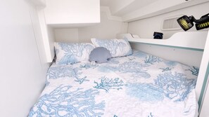 A bunk bed with a white and blue ocean-themed bedding.