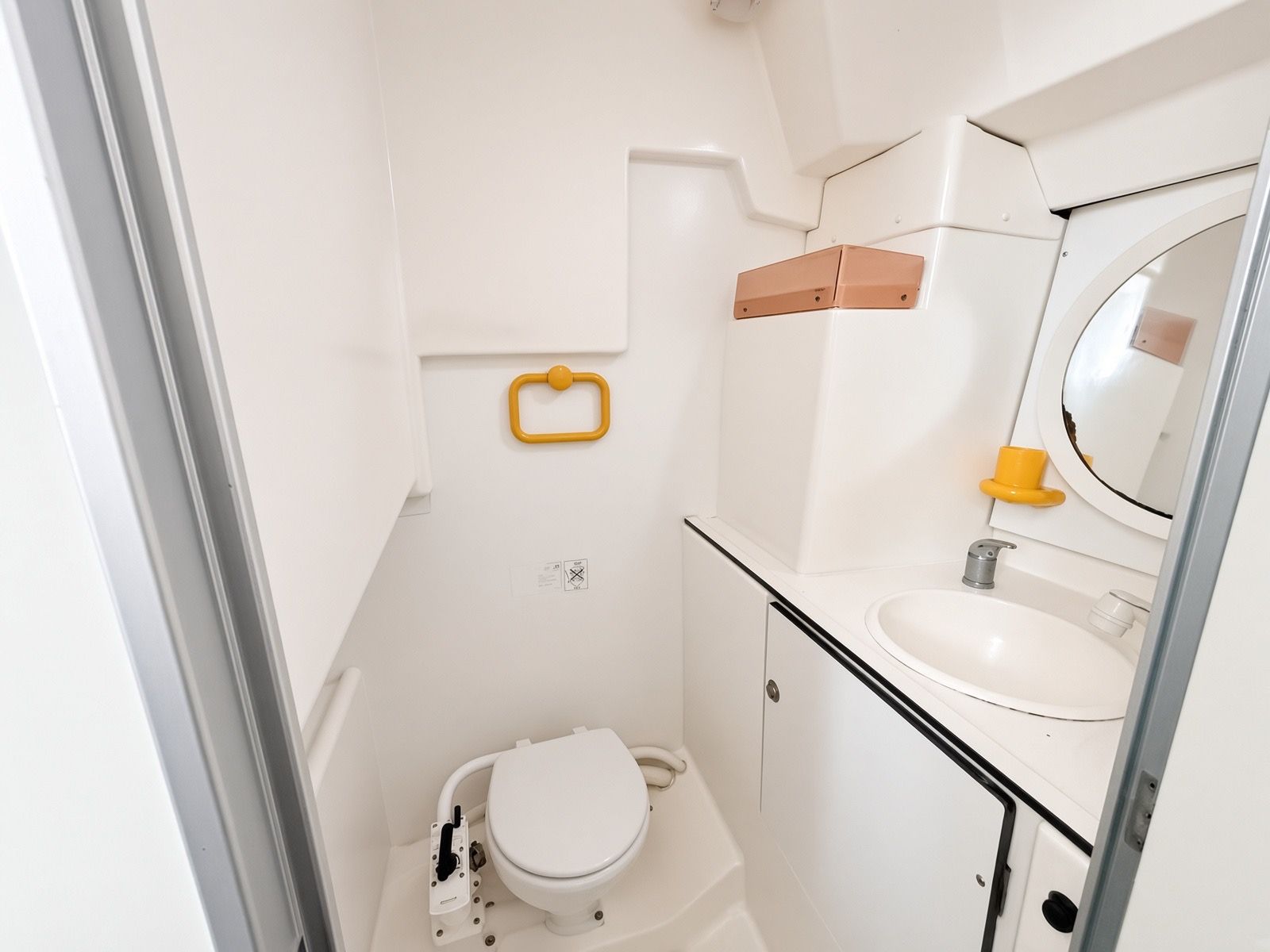 Ein kleines Badezimmer mit Toilette, Waschbecken und Spiegel.