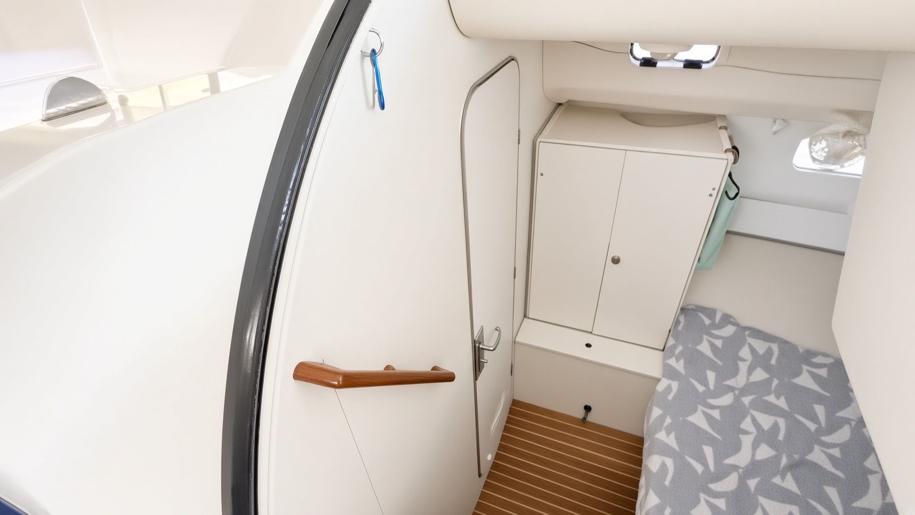 A compact interior with a door, a small cabinet, and a patterned fabric.