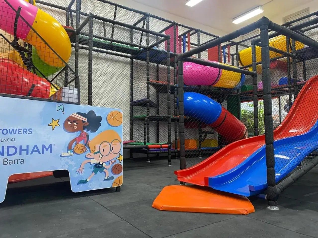 A playground area with multiple slides and a netted play structure.