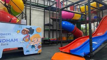 A playground area with multiple slides and a netted play structure.