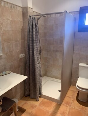 Une salle de bain avec une douche, des toilettes et un lavabo.