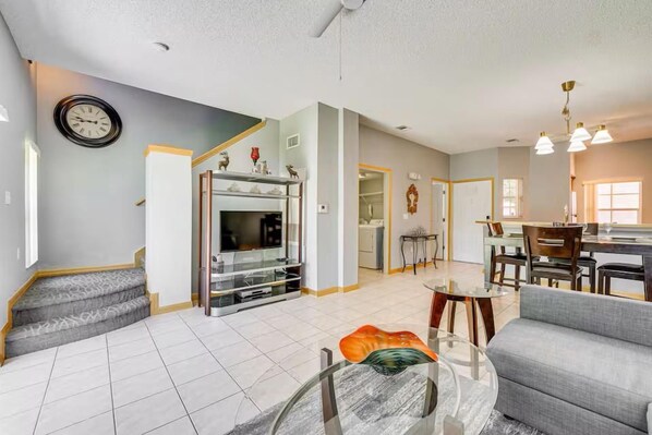 A spacious living area with a fireplace, a dining table, and a sofa. - 3 Bed Emerald Island Resort Townhouse (KISSIMMEE)
