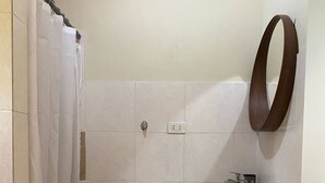 A bathroom with a shower curtain, a sink, a mirror, and a towel rack.