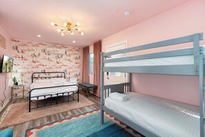 A bunk bed room with a ceiling light fixture, a wall-mounted air conditioner, and a patterned wall. - Paradise Palms - Scottsdale 4BR w/ Heated Pool, Fire Pit, PingPong (Scottsdale)