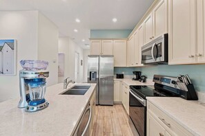 A modern kitchen with a stainless steel refrigerator, a built-in microwave, a coffee maker, and a Samsung oven. - Palm Paradise Cottage near Disney | Private Pool & Resort Access - 8017ST (Kissimmee)