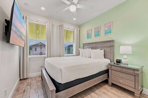 Une chambre d’hôtel équipée d’un lit, d’une table de chevet, d’une lampe et d’un téléviseur fixé au mur.