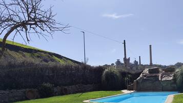 Une piscine avec des chaises longues et une pelouse.
