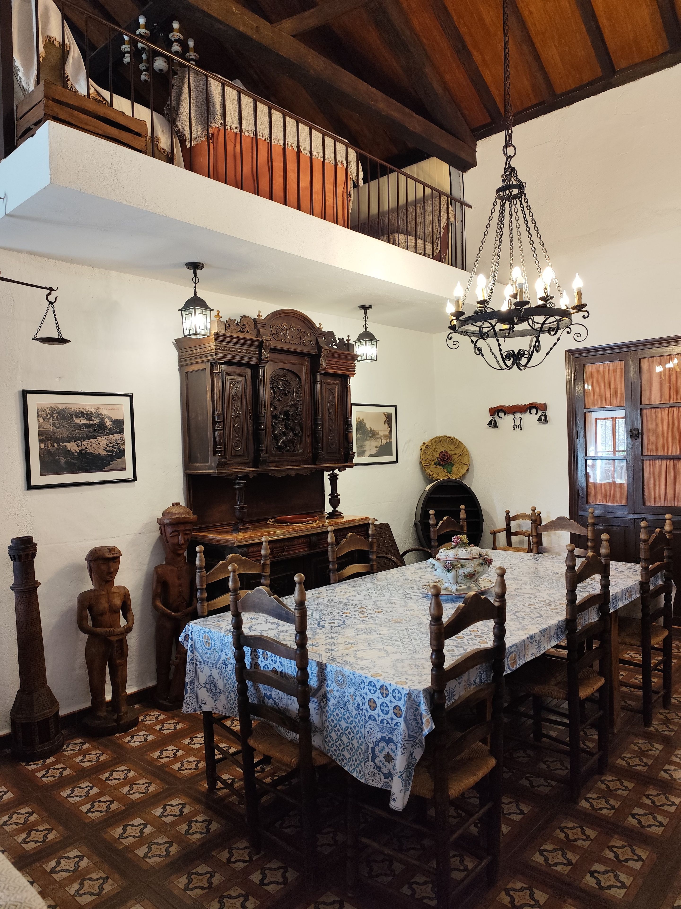 A dining area with a wooden table, chairs, and a chandelier.