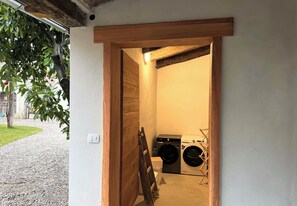 Una sala de lavandería con dos lavadoras y un tendedero.