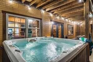 A hot tub in a rustic wooden room with large windows and a visible interior. - Abode at Big Pine – Formerly Western Hideaway (Logan)