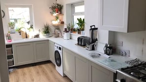 Eine moderne Küche mit Waschmaschine, Toaster und Kaffeemaschine.