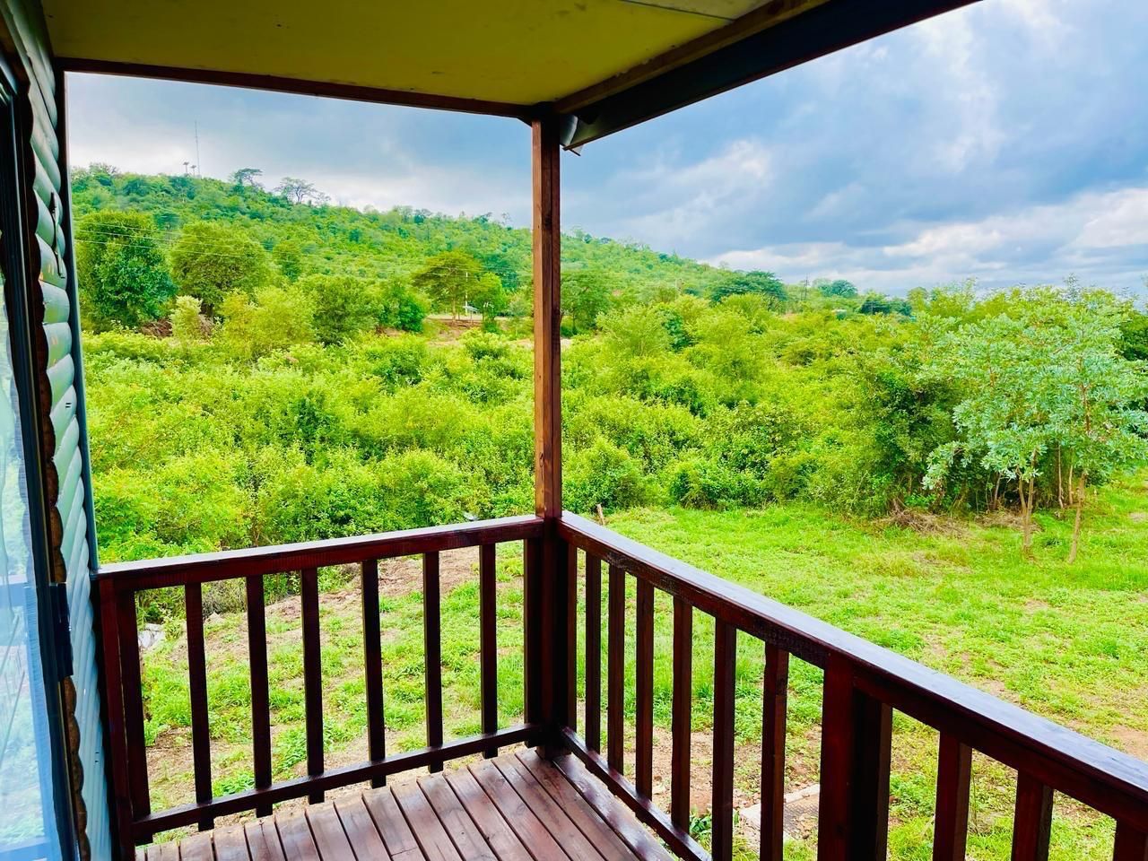 Ein Holzbalkon mit Blick auf eine üppige, grüne Landschaft.