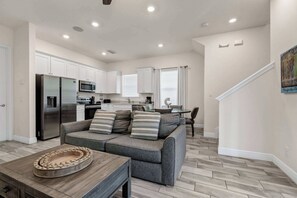 A modern kitchen with white cabinets, a stainless steel refrigerator, and a microwave. - Sun Shack Cottage | Private Pool Near Disney & Island H2O Access - 8096KD (Kissimmee)