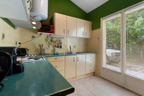 A kitchen with a gas stove, a microwave, and cabinets. - Country House 'Mas Saint Joseph' with Private Pool, Private Terrace and Wi-Fi (Meynes)