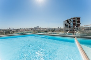 A rooftop swimming pool with a cityscape view. - GuestReady-Luxurious Retreat with Rooftop Pool (Vila Nova de Gaia)