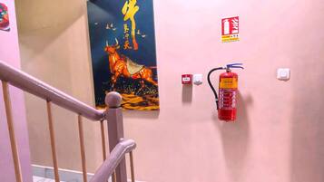 A staircase with a fire extinguisher mounted on the wall and a fire safety sign.