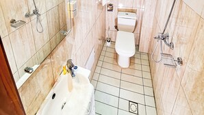 Un baño con bañera, inodoro y zona de ducha.
