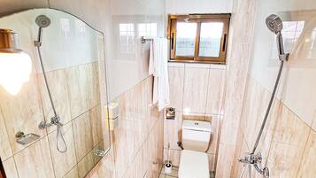 Une salle de bain comprenant une baignoire, des toilettes et un espace douche.