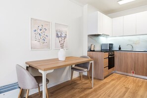 A modern kitchen with a wooden countertop, a built-in oven, and a stainless steel sink. - GuestReady - Charming Studio in Porto's Heart (Porto)