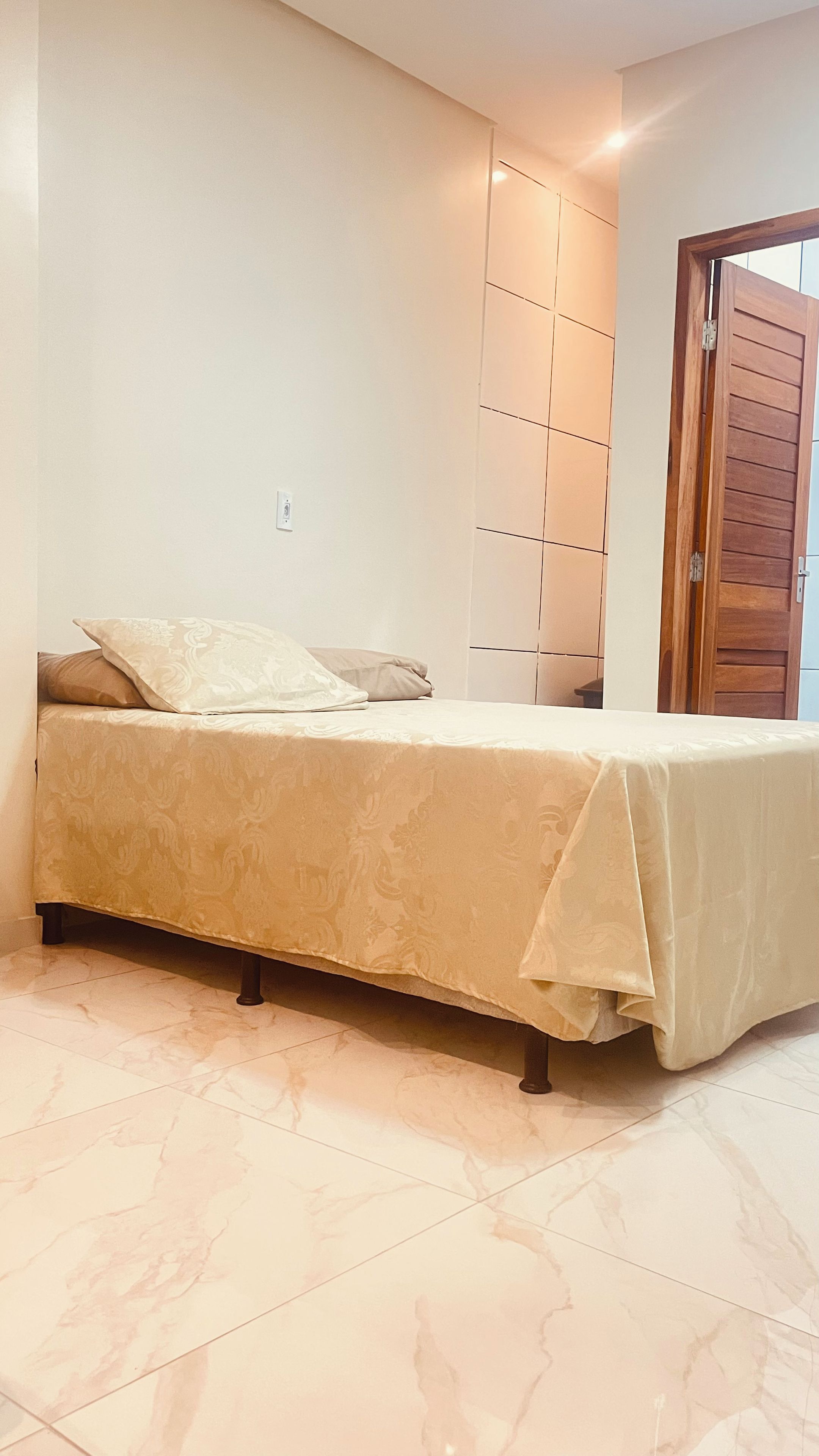 A bedroom with a bed, a wardrobe, and a door.