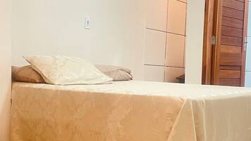 A bedroom with a bed, a wardrobe, and a door.