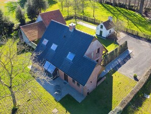 A two-story house with a sloped roof, a small attached garage, and a paved driveway.