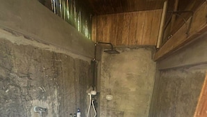 Baño pequeño y funcional con orinal, inodoro y ducha.