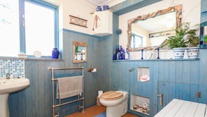 A bathroom with a toilet, sink, and towel rack. - Dunvant (Swanage)