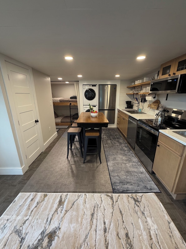A compact kitchen with a central island, built-in appliances, and a small dining area.