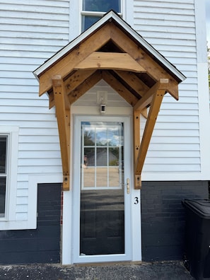 A house with a white exterior, a black door, and a number '3' on the wall.