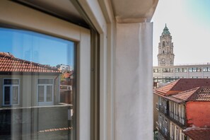 A view from a window overlooking a cityscape with a prominent clock tower. - GuestReady - Nárnia (Porto)