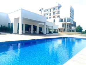 Un edificio moderno con piscina frente a él.