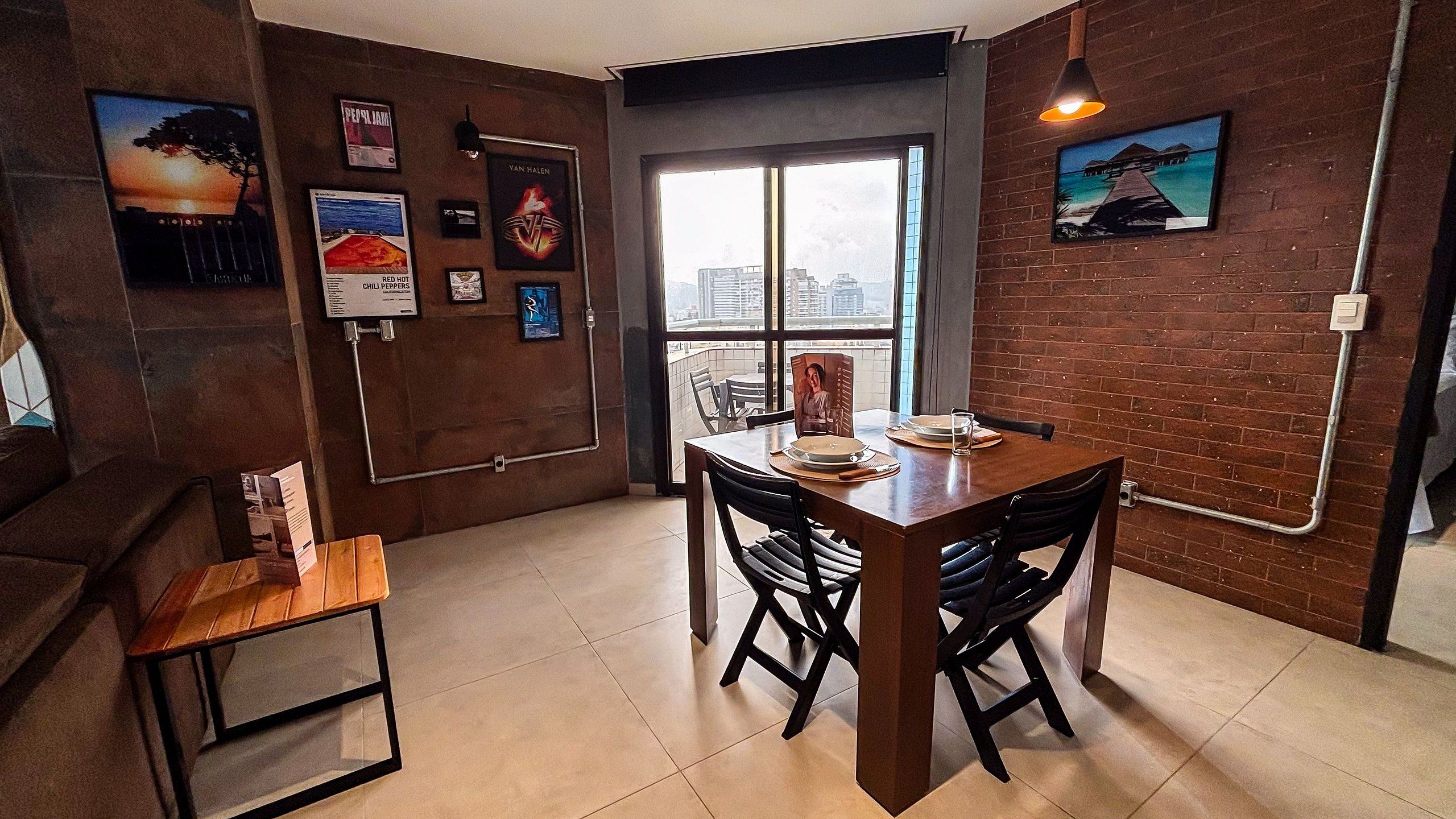 Un comedor con pared de ladrillo, una ventana con vistas y una mesa con sillas.