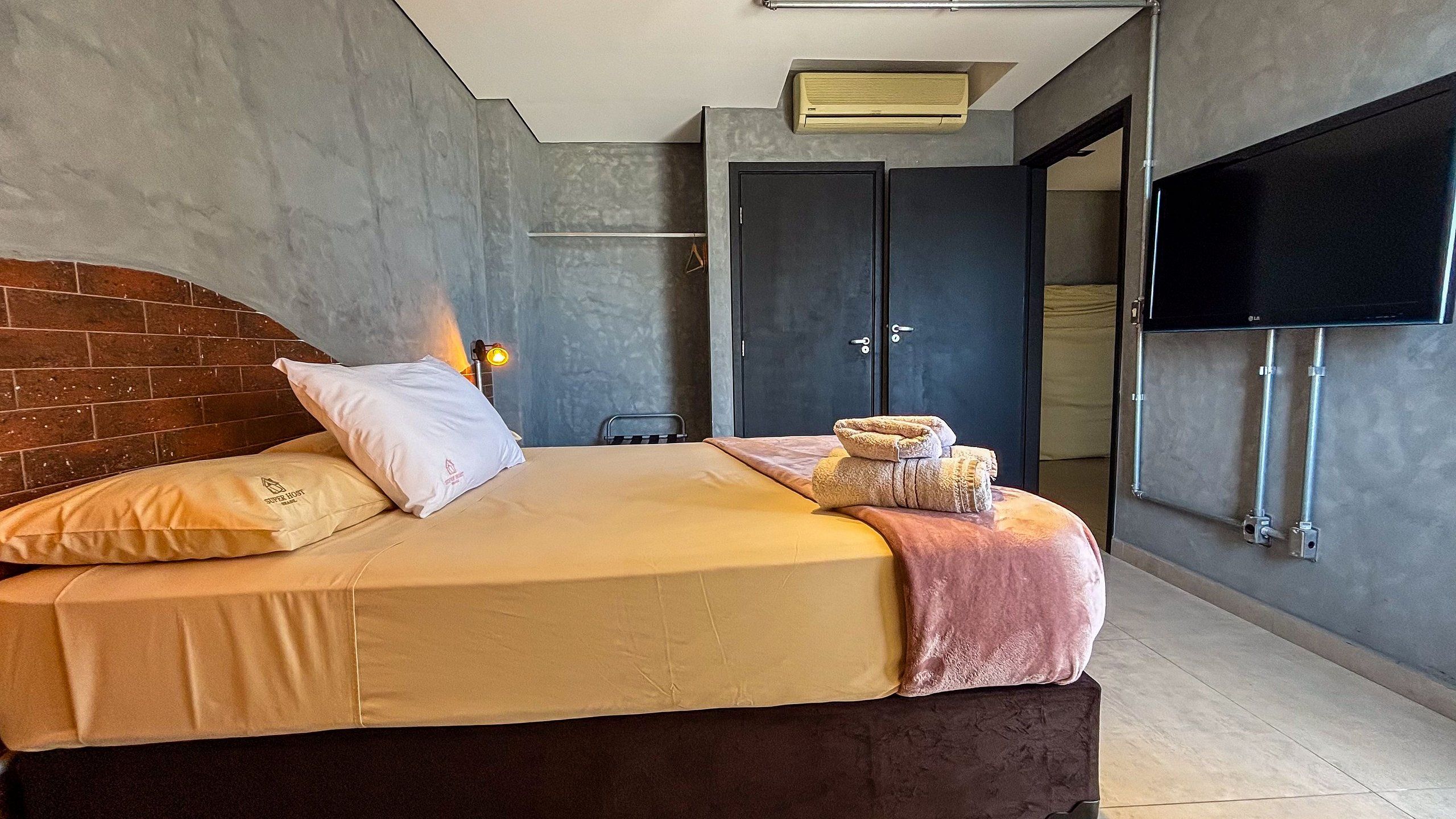 Habitación de hotel con cama, televisor de pantalla plana, armario y calefacción.