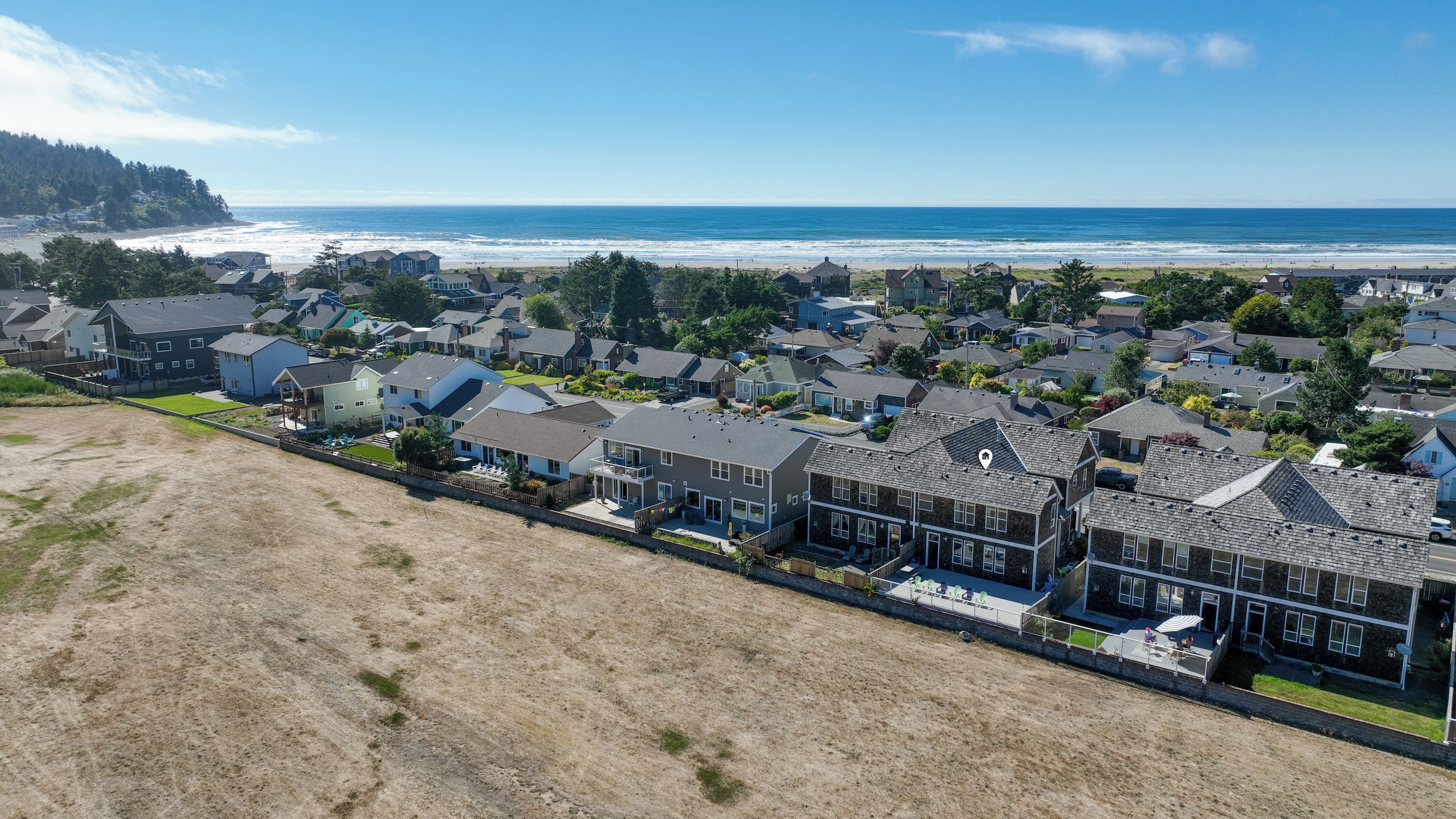 Un quartier résidentiel situé sur la côte, avec des maisons, une plage et une vue dégagée sur l’océan.