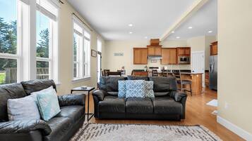 A spacious living area with a leather sofa, a coffee table, and a rug.