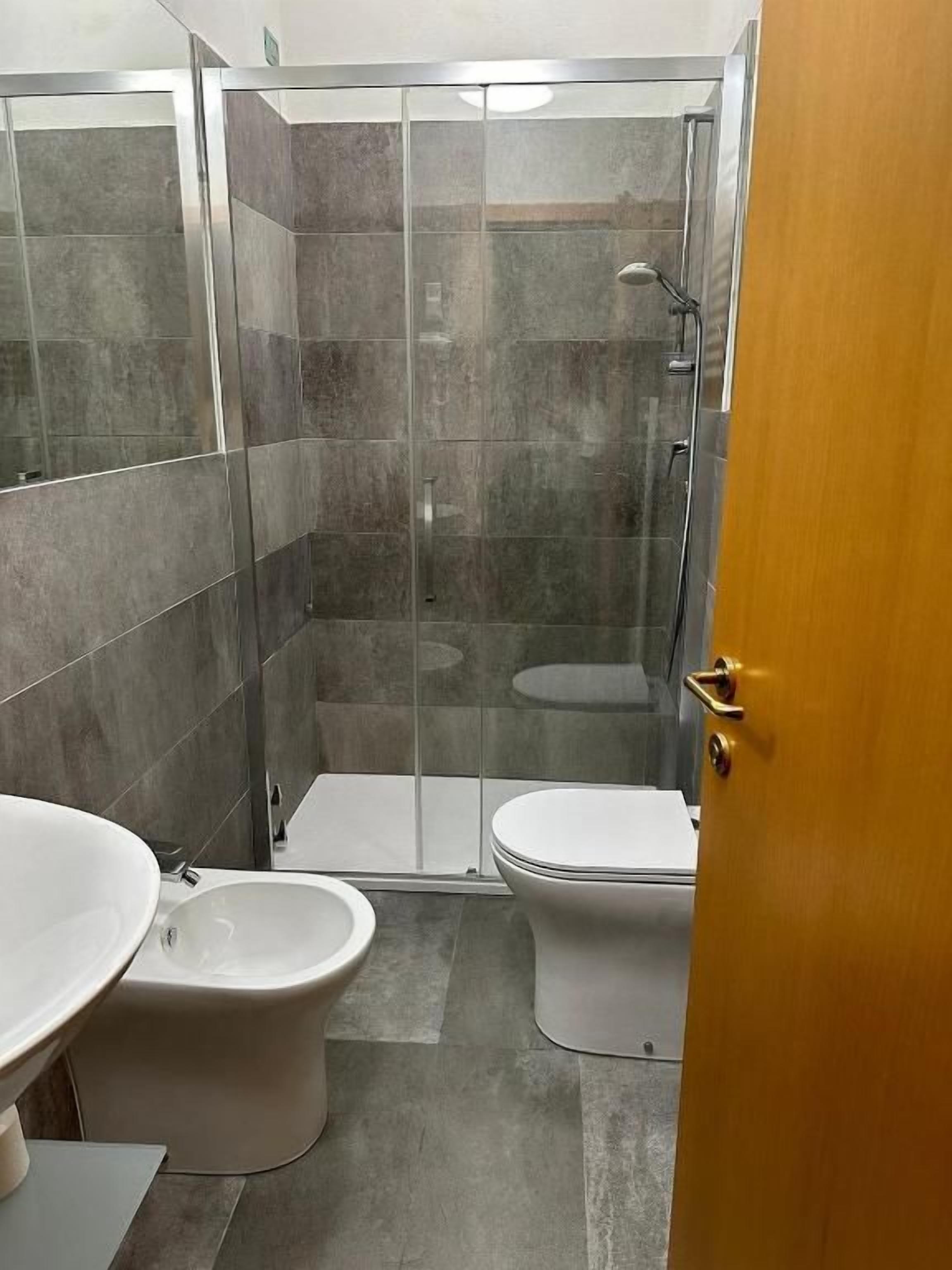 Ein Badezimmer mit einer Duschkabine, einer Toilette und einem Bidet.