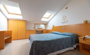 A bedroom with a bed, a desk, a wardrobe, a mirror, and skylights. - Hotel Garden (Bologna)