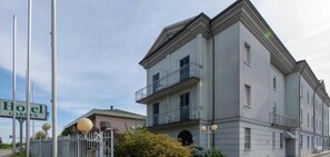 A multi-story hotel with balconies, a garden sign, and a well-maintained exterior. - Hotel Garden (Bologna)