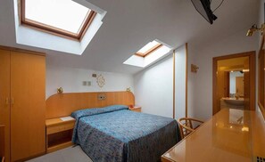 A bedroom with a bed, a desk, and a mirror. There are skylights on the ceiling. - Hotel Garden (Bologna)