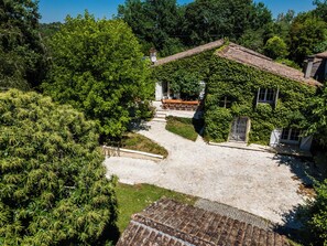 A traditional house with a stone pathway leading to the entrance, surrounded by lush greenery. - La Guate - Maison avec piscine - Saint-Émilion (Daubèze)