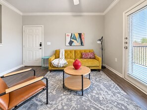 A living room with a sofa, a coffee table, and a chair. - Sleepover | Tranquil 1BD/1BA+ Gym - Corpus Christi (Corpus Christi)