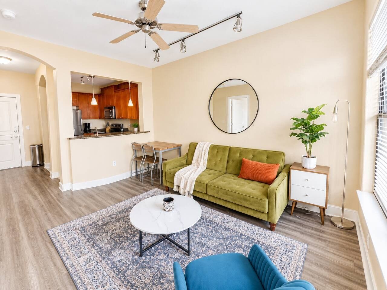 A living room with a green sofa, a coffee table, and a ceiling fan.