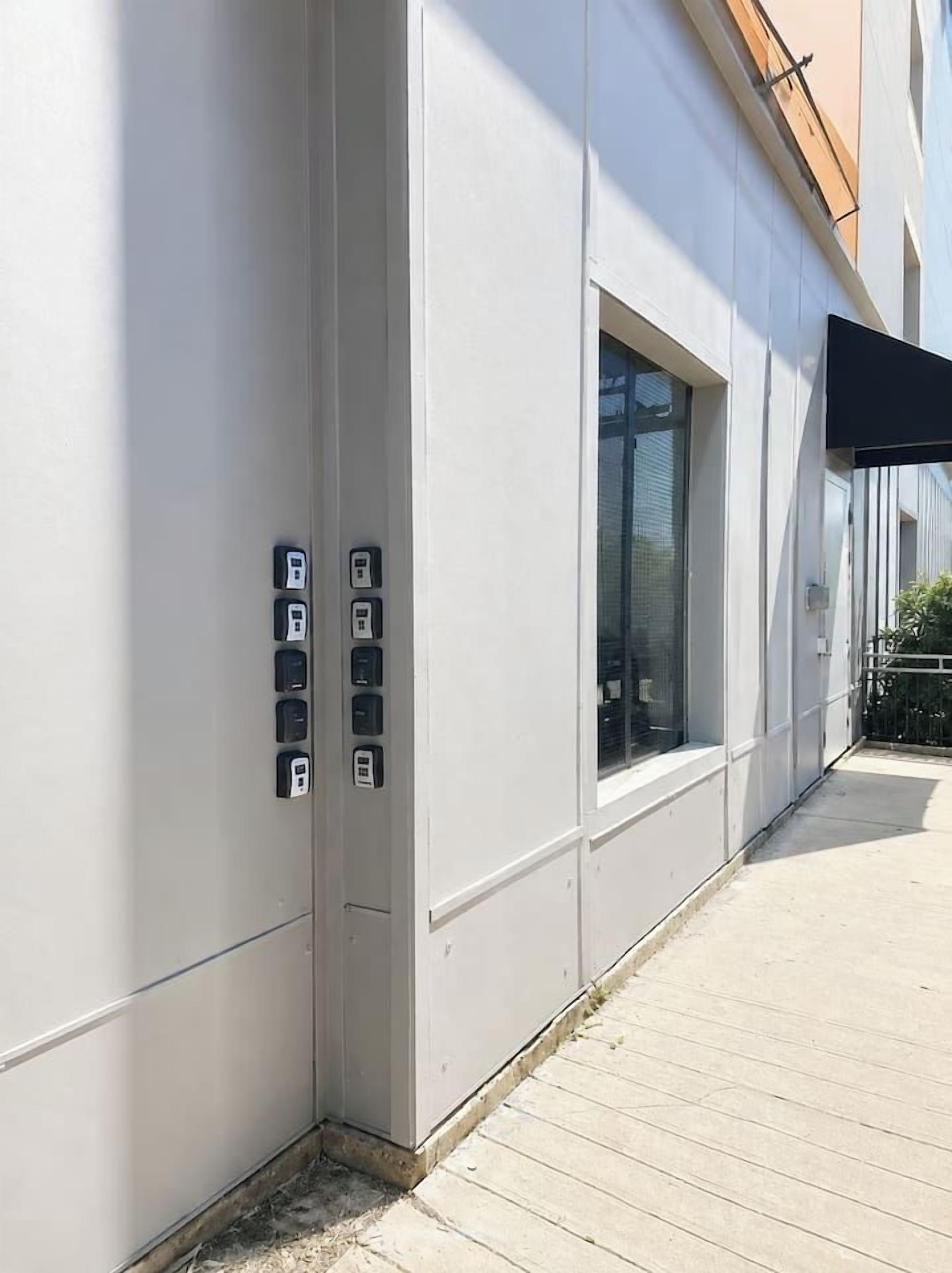 Fachada de un edificio de diseño moderno, con un ventanal grande y una serie de cajas eléctricas en la pared.